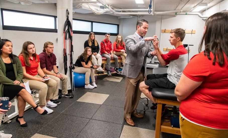 Students gather for a demonstration during an athletic training class.